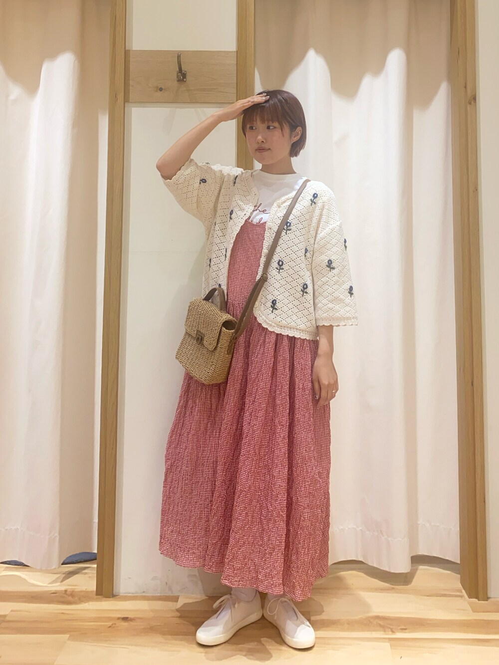 レッド系のワンピース、ホワイト系のカーディガン/ボレロ、ホワイト系のTシャツ/カットソーを着用したレディースの春コーディネートの2枚目の写真