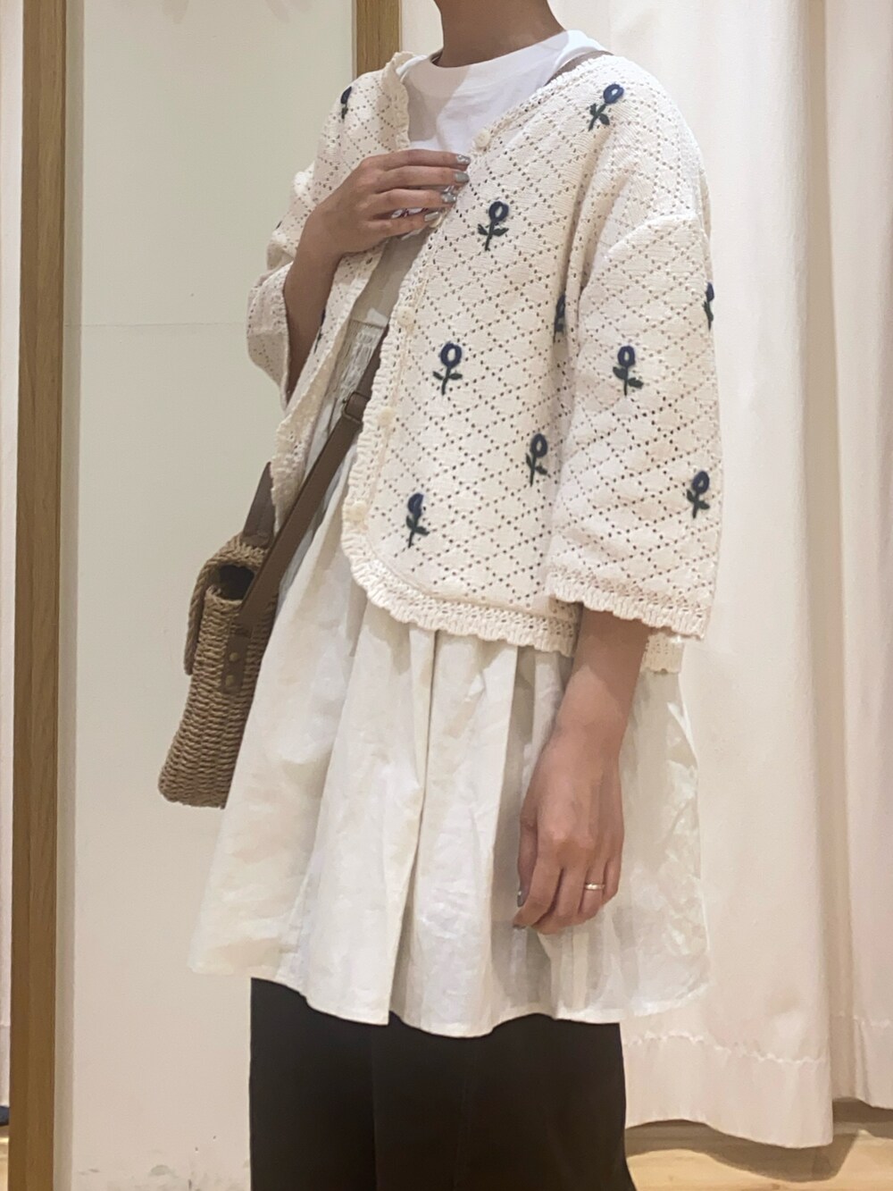 ホワイト系のカーディガン/ボレロ、ホワイト系のTシャツ/カットソー、ベージュ系のハンドバッグを着用したレディースの春コーディネートの4枚目の写真