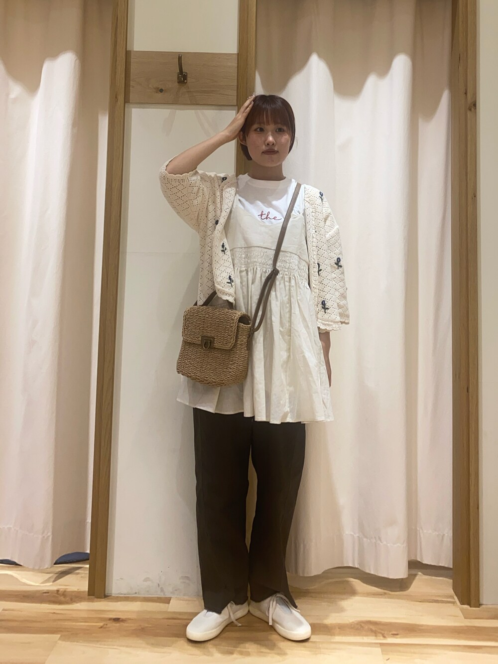 ホワイト系のカーディガン/ボレロ、ホワイト系のTシャツ/カットソー、ベージュ系のハンドバッグを着用したレディースの春コーディネートの2枚目の写真