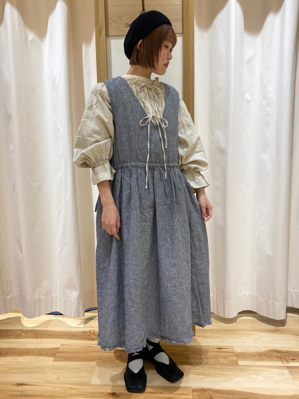 ブラック系のワンピース、ベージュ系のトップス、ホワイト系のTシャツ/カットソーを着用したレディースの春コーディネートの2枚目の写真