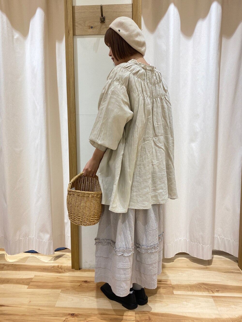 グレー系のスカート、ホワイト系のTシャツ/カットソー、ベージュ系のトップスを着用したレディースの春コーディネートの4枚目の写真