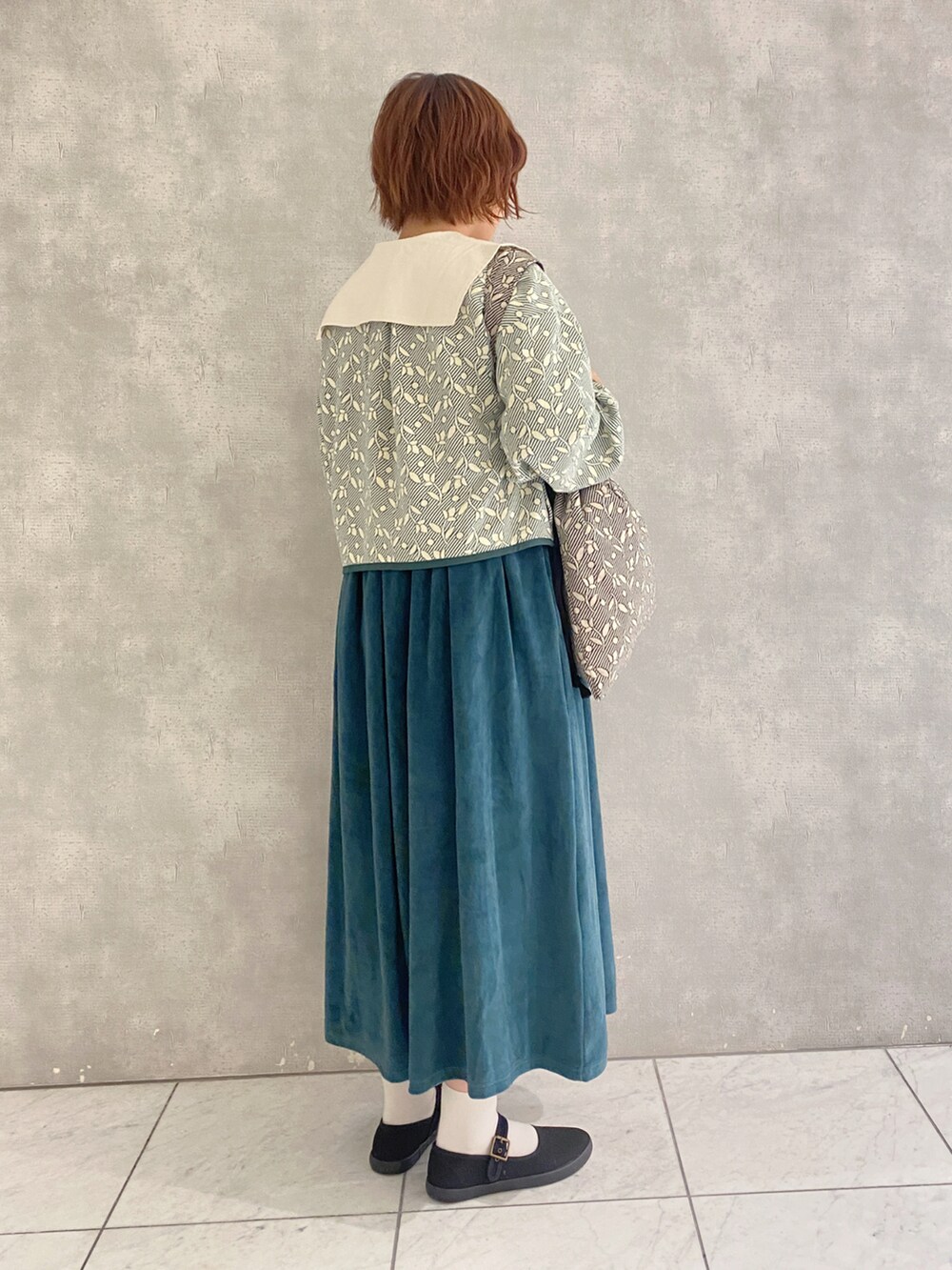 ベージュ系のハンドバッグ、ホワイト系のシャツ/ブラウス、グリーン系のノーカラージャケットを着用したレディースの秋コーディネートの3枚目の写真
