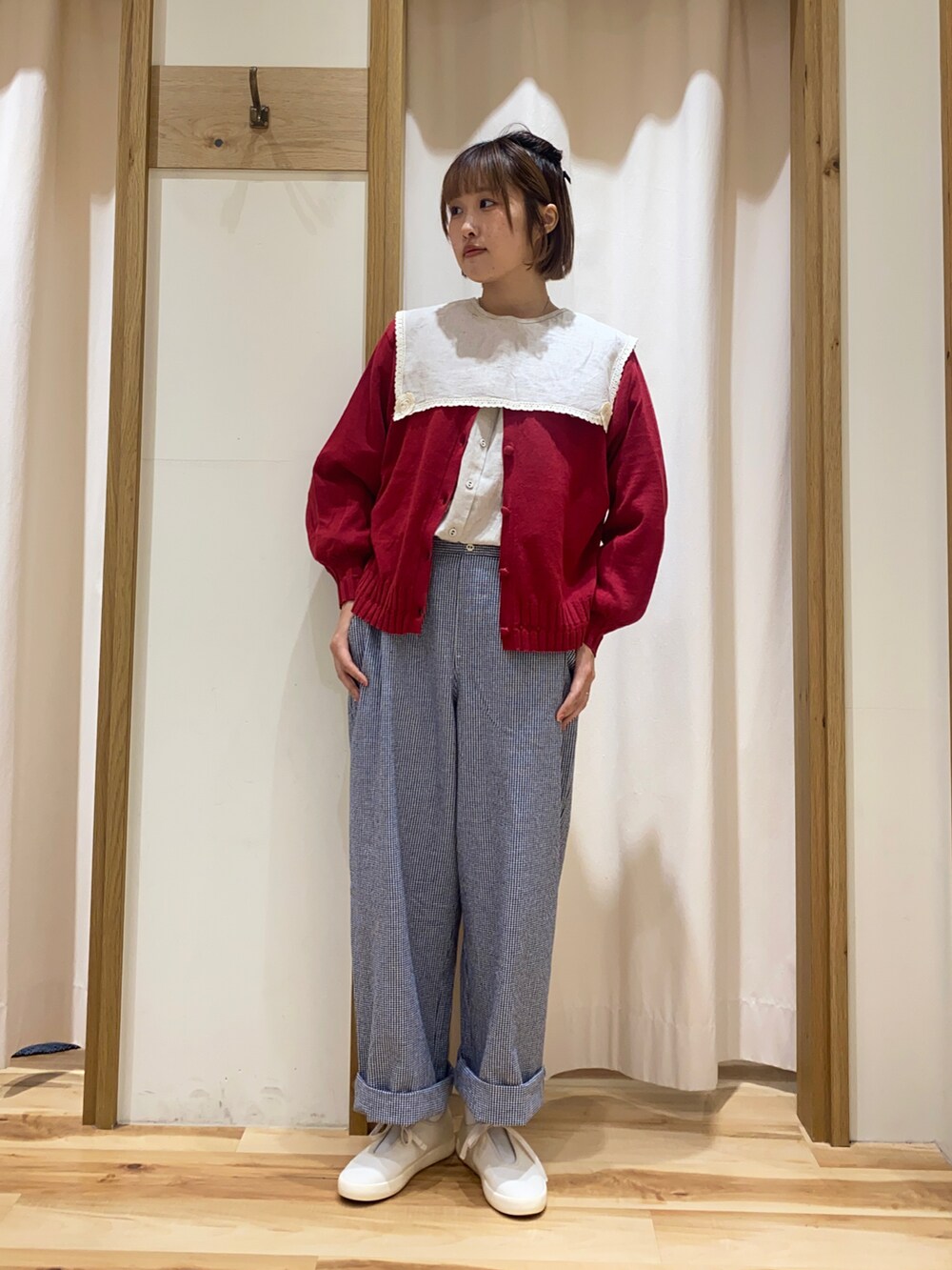 レッド系のカーディガン/ボレロ、ベージュ系のシャツ/ブラウス、ブラック系のパンツを着用したレディースの春コーディネートの2枚目の写真