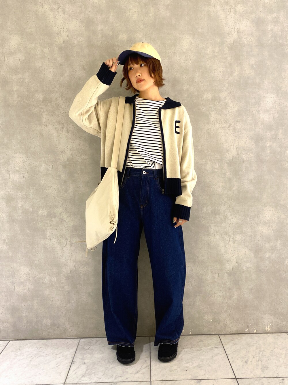 ホワイト系のカーディガン/ボレロ、ホワイト系のTシャツ/カットソー、ブルー系のデニムパンツを着用したレディースの秋コーディネートの2枚目の写真