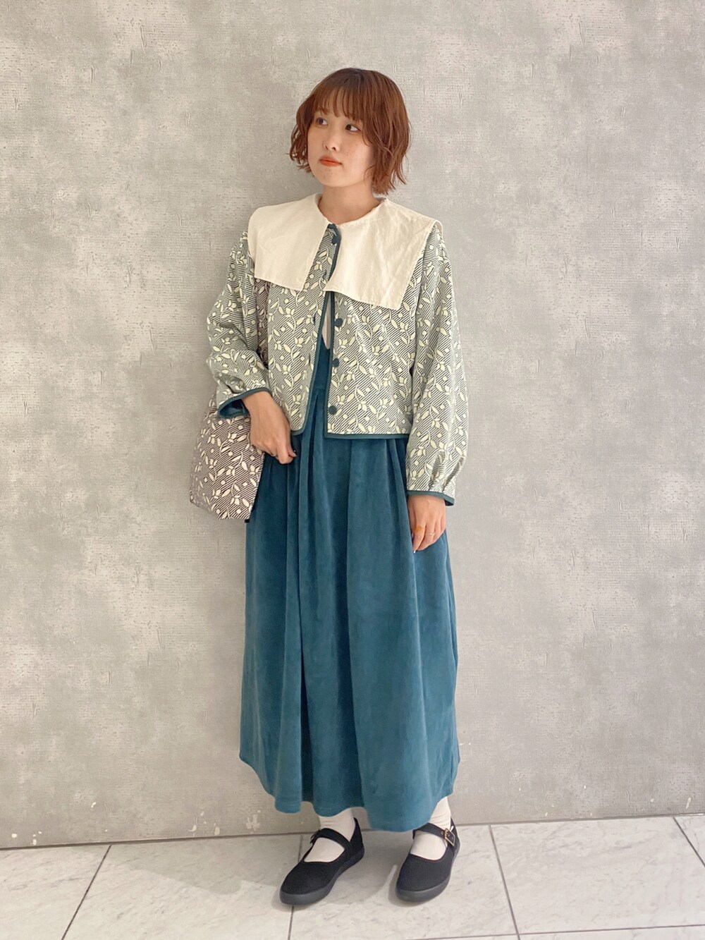 ベージュ系のハンドバッグ、ホワイト系のシャツ/ブラウス、グリーン系のノーカラージャケットを着用したレディースの秋コーディネートの2枚目の写真