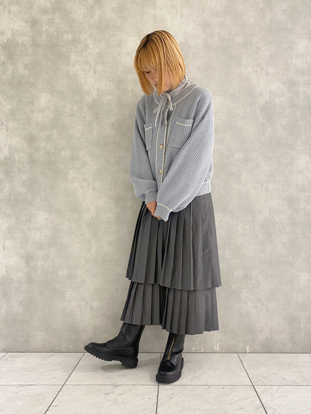 グレー系のスカート、ブルー系のカーディガン/ボレロ、グレー系のシャツ/ブラウスを着用したレディースの秋コーディネートの2枚目の写真