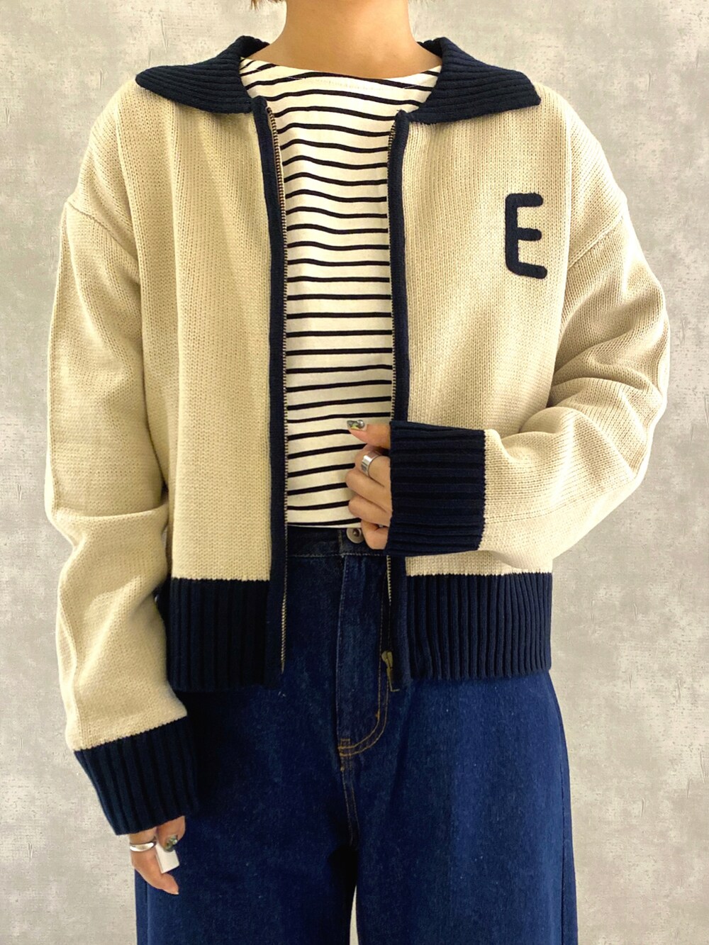 ホワイト系のカーディガン/ボレロ、ホワイト系のTシャツ/カットソー、ブルー系のデニムパンツを着用したレディースの秋コーディネートの4枚目の写真