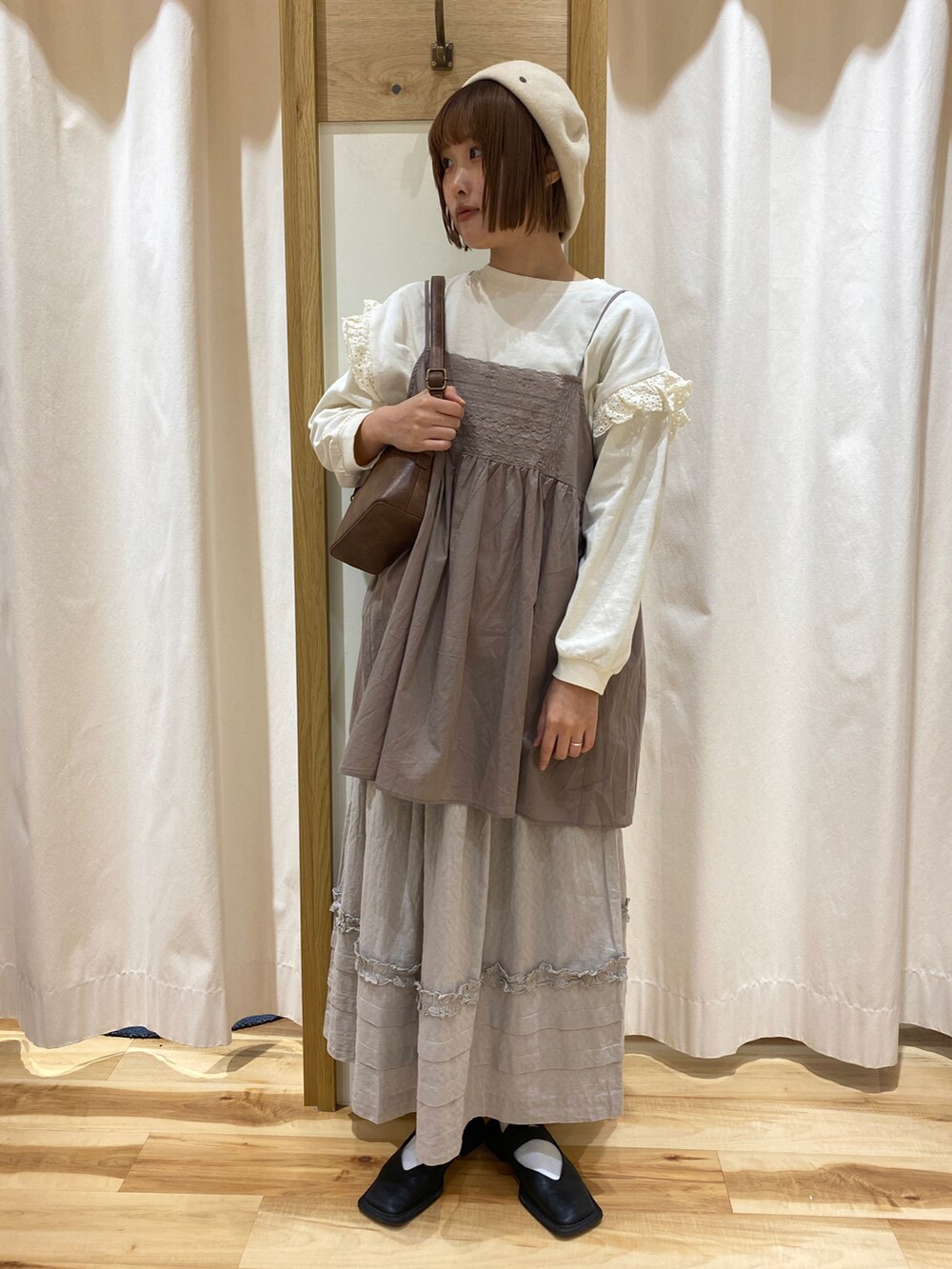 ホワイト系のTシャツ/カットソー、ブラウン系のハンドバッグ、ベージュ系のシャツ/ブラウスを着用したレディースの春コーディネートの2枚目の写真