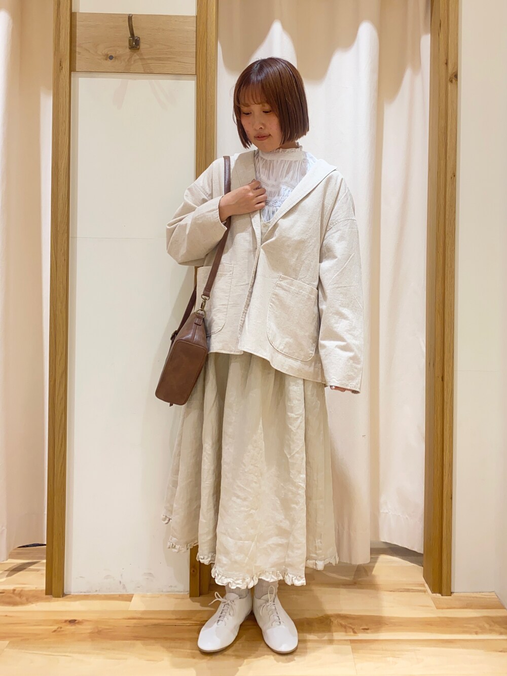 ベージュ系のテーラードジャケット、ホワイト系のシャツ/ブラウス、ブラウン系のハンドバッグを着用したレディースの春コーディネートの2枚目の写真