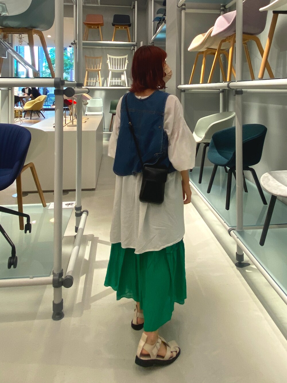 ブルー系のベスト、ホワイト系のシャツ/ブラウス、グリーン系のスカートを着用したレディースの夏コーディネートの2枚目の写真