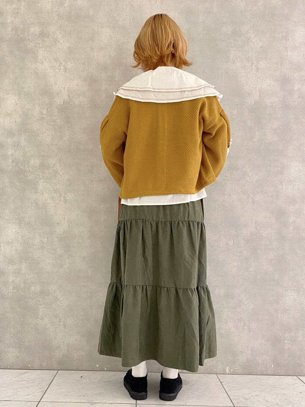 イエロー系のカーディガン/ボレロ、イエロー系のハンドバッグ、ブラック系のその他シューズを着用したレディースの秋コーディネートの4枚目の写真