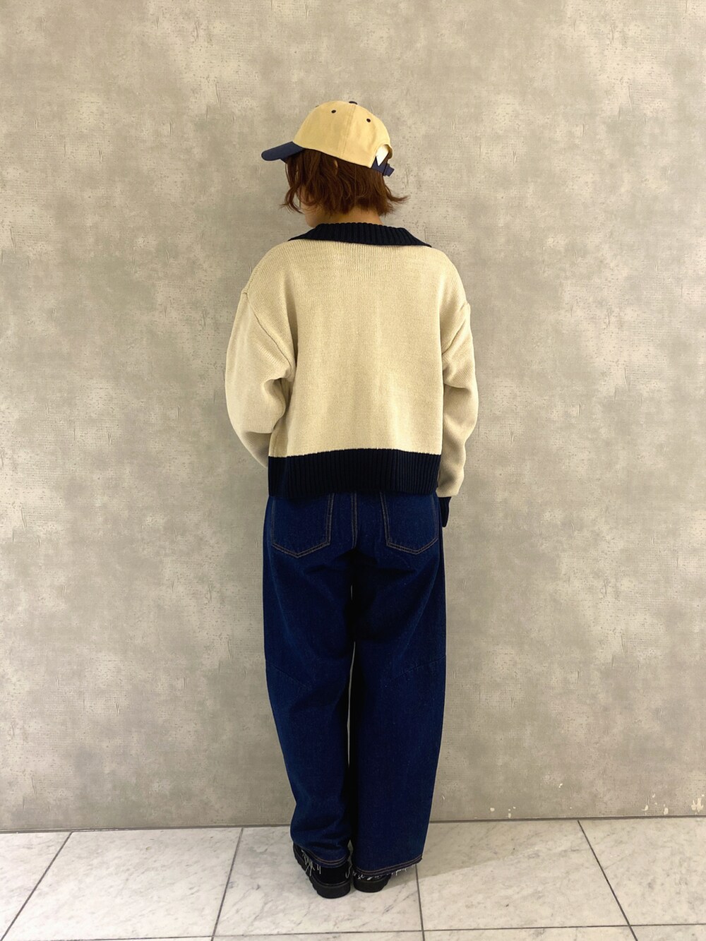 ホワイト系のカーディガン/ボレロ、ホワイト系のTシャツ/カットソー、ブルー系のデニムパンツを着用したレディースの秋コーディネートの3枚目の写真