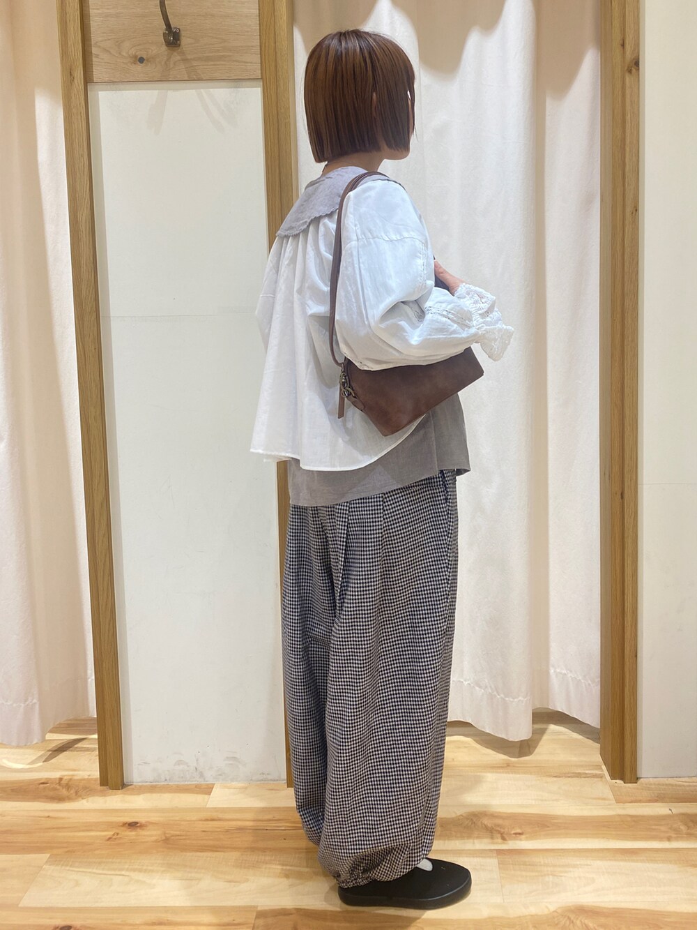 ホワイト系のシャツ/ブラウス、グレー系のその他パンツ、ブラウン系のハンドバッグを着用したレディースの春コーディネートの4枚目の写真