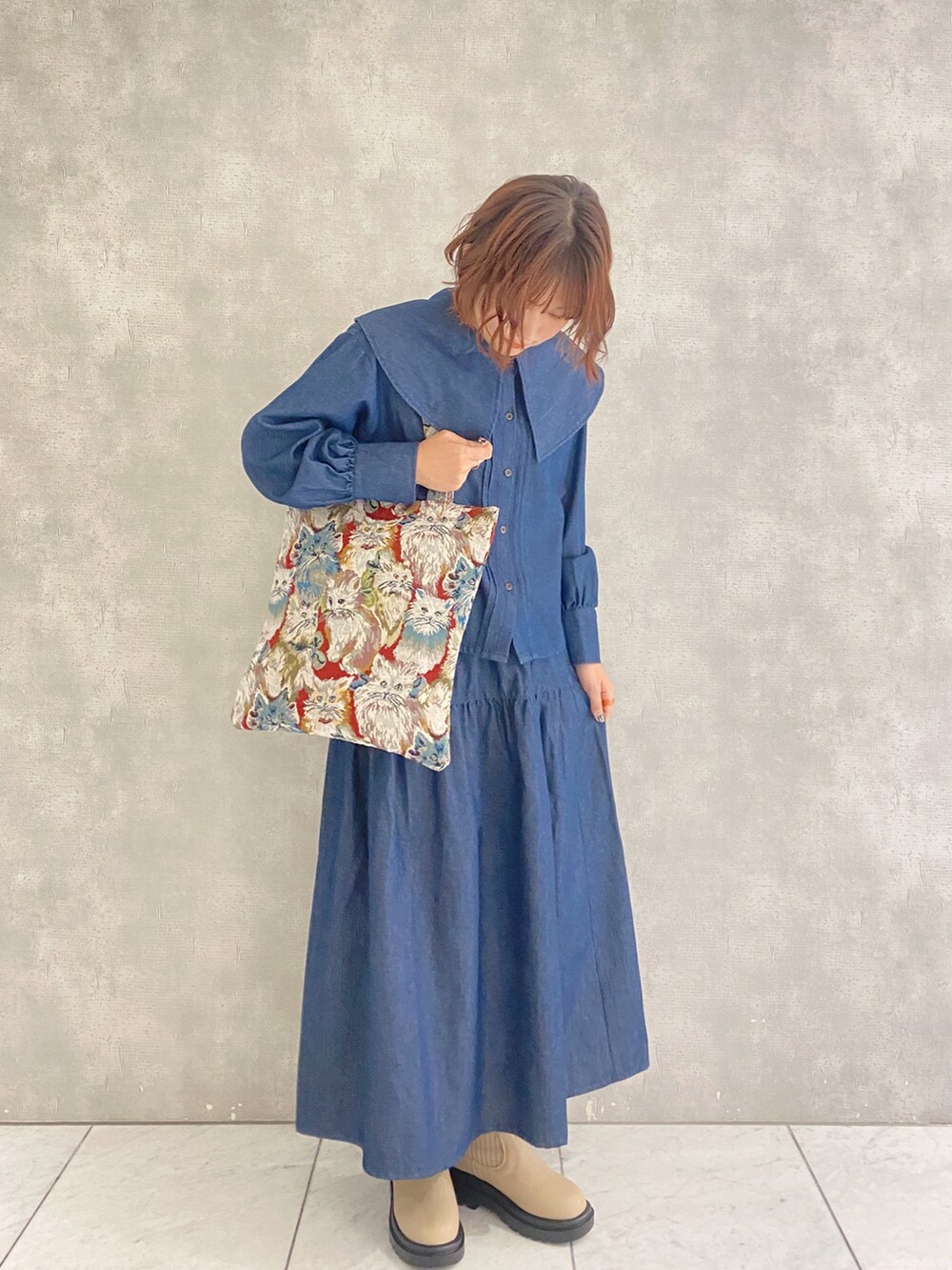 ブルー系のシャツ/ブラウス、ブルー系のスカート、ベージュ系のブーツを着用したレディースの秋コーディネートの2枚目の写真