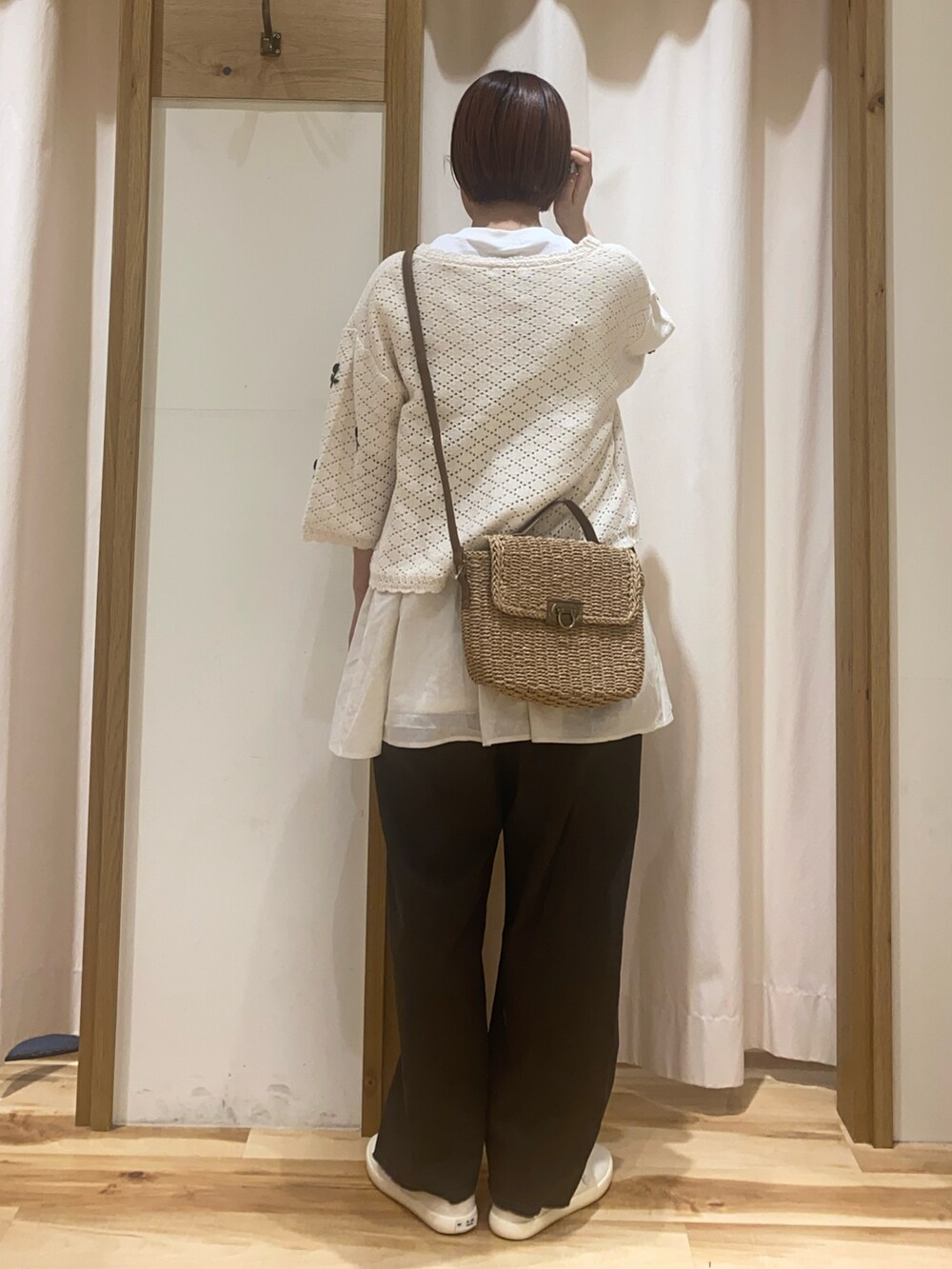 ホワイト系のカーディガン/ボレロ、ホワイト系のTシャツ/カットソー、ベージュ系のハンドバッグを着用したレディースの春コーディネートの3枚目の写真