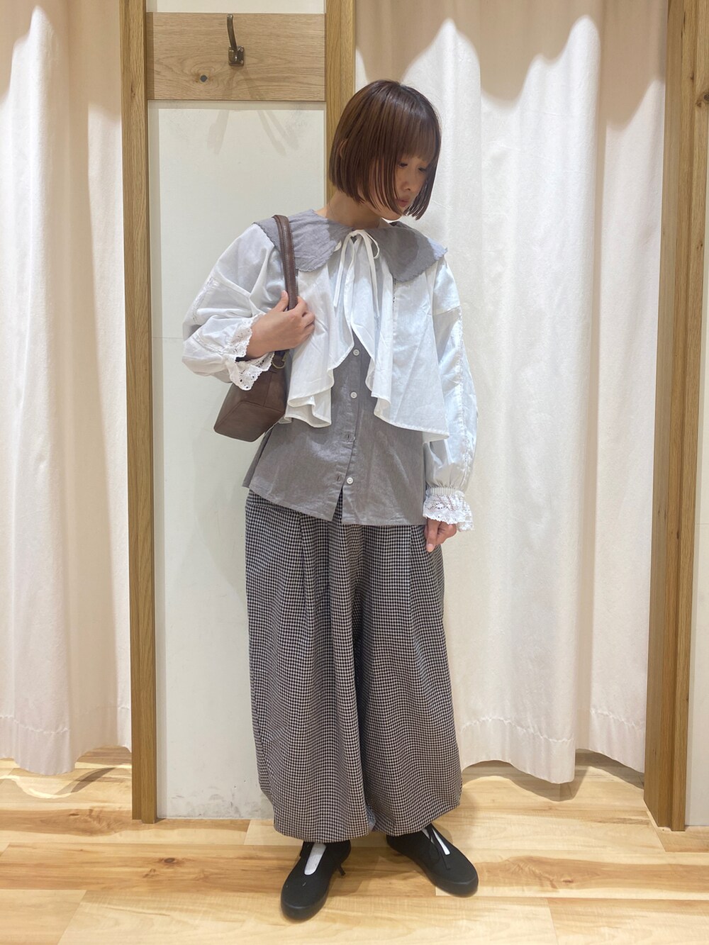 ホワイト系のシャツ/ブラウス、グレー系のその他パンツ、ブラウン系のハンドバッグを着用したレディースの春コーディネートの5枚目の写真