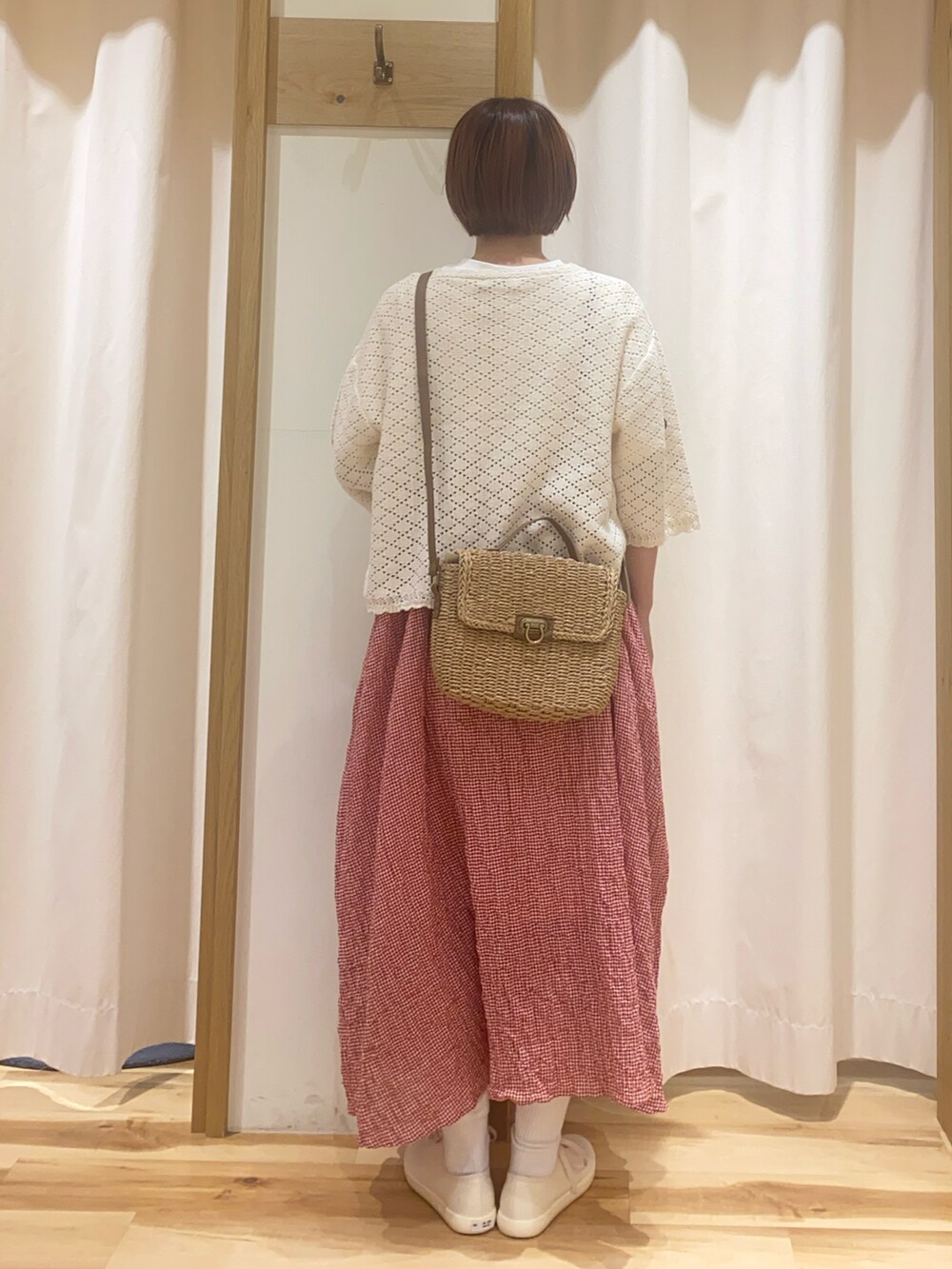 レッド系のワンピース、ホワイト系のカーディガン/ボレロ、ホワイト系のTシャツ/カットソーを着用したレディースの春コーディネートの3枚目の写真