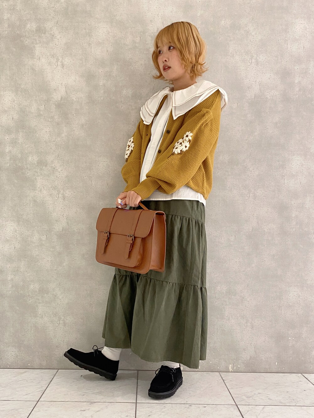 イエロー系のカーディガン/ボレロ、イエロー系のハンドバッグ、ブラック系のその他シューズを着用したレディースの秋コーディネートの3枚目の写真