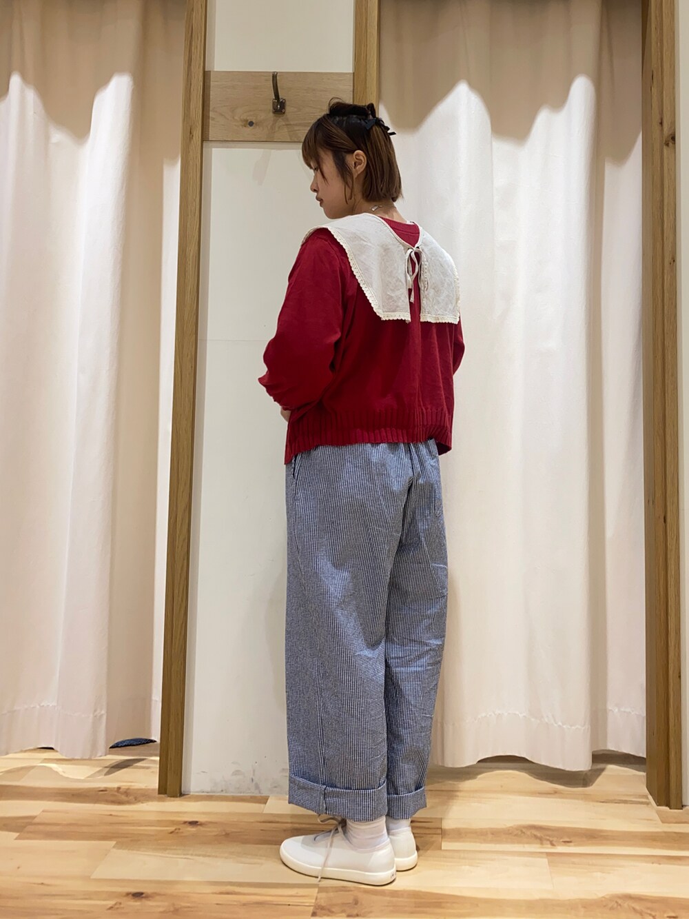 レッド系のカーディガン/ボレロ、ベージュ系のシャツ/ブラウス、ブラック系のパンツを着用したレディースの春コーディネートの3枚目の写真