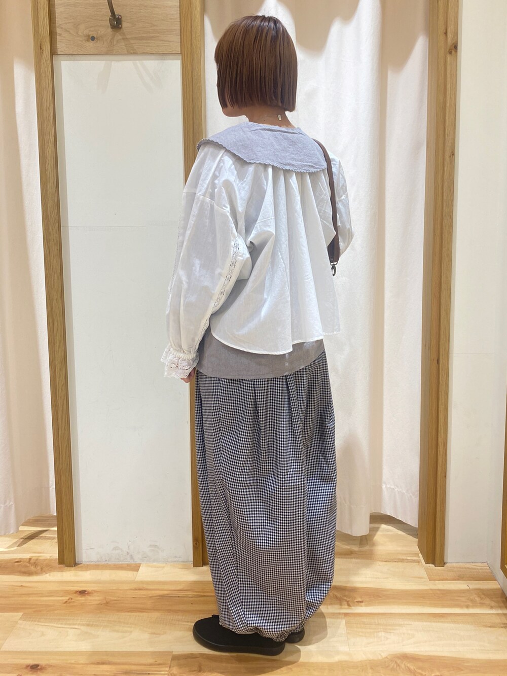 ホワイト系のシャツ/ブラウス、グレー系のその他パンツ、ブラウン系のハンドバッグを着用したレディースの春コーディネートの2枚目の写真