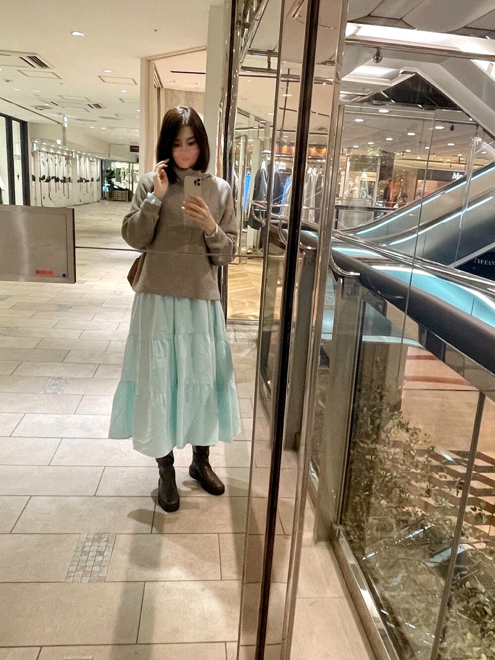 グレー系のニット/セーター、ブラウン系のバッグ、ブラウン系のブーツを着用したレディースの秋コーディネートの3枚目の写真