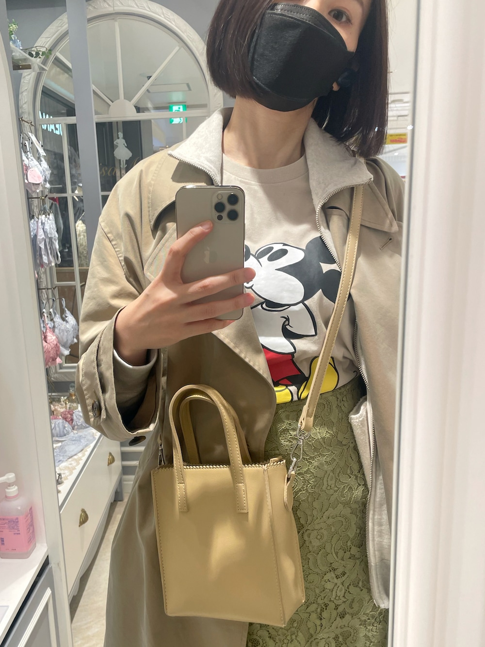 ベージュ系のTシャツ/カットソー、グリーン系のスカート、ベージュ系のトレンチコートを着用したレディースの春コーディネートの2枚目の写真