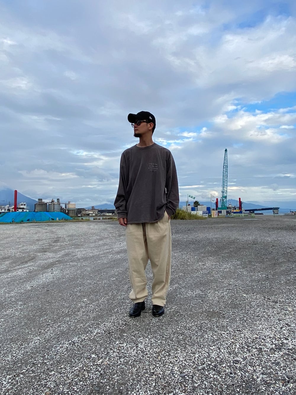 ブラウン系のTシャツ/カットソー、ホワイト系のパンツ、ブラック系のブーツを着用したメンズの秋コーディネートの2枚目の写真