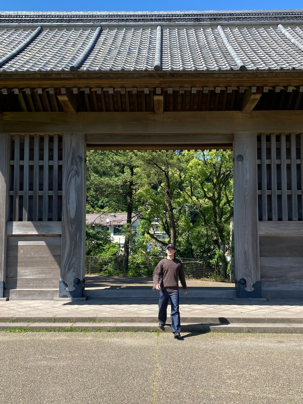 ブルー系のデニムパンツ、ブラック系のその他シューズ、ブラウン系のTシャツ/カットソーを着用したメンズの夏コーディネートの2枚目の写真