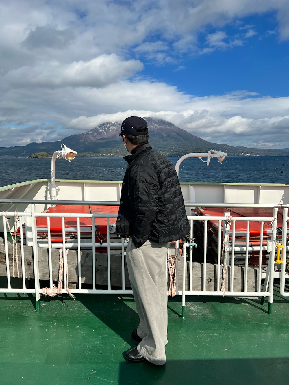 ブルー系のスウェット、ブラック系のダウンジャケット/コート、グレー系のデニムパンツを着用したメンズの冬コーディネートの2枚目の写真