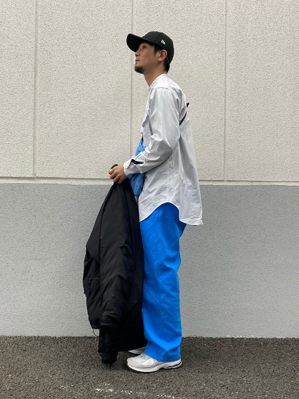 ホワイト系のシャツ/ブラウス、ブラック系のダウンジャケット/コート、ブルー系のバッグを着用したメンズの春コーディネートの2枚目の写真