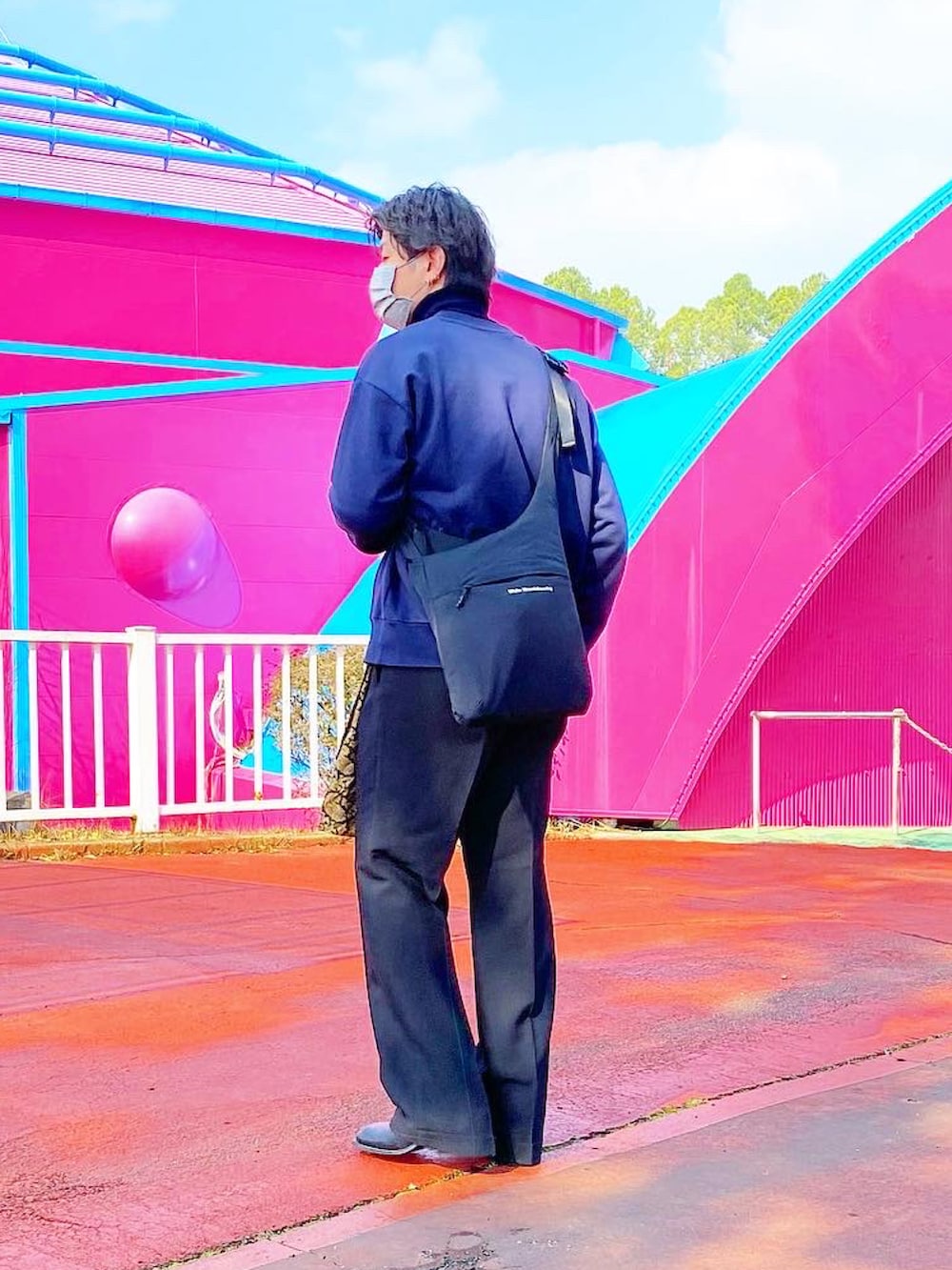 ブルー系のスウェット、ブラック系のスラックス、ブラック系のブーツを着用したメンズの春コーディネートの2枚目の写真