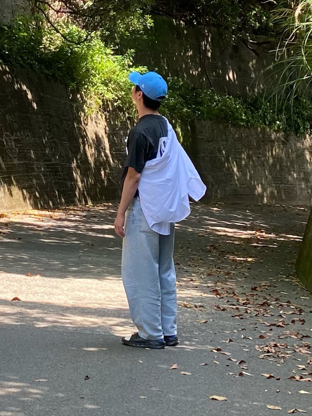 ブラック系のTシャツ/カットソー、ホワイト系のシャツ/ブラウス、ブルー系のデニムパンツを着用したメンズの夏コーディネートの2枚目の写真