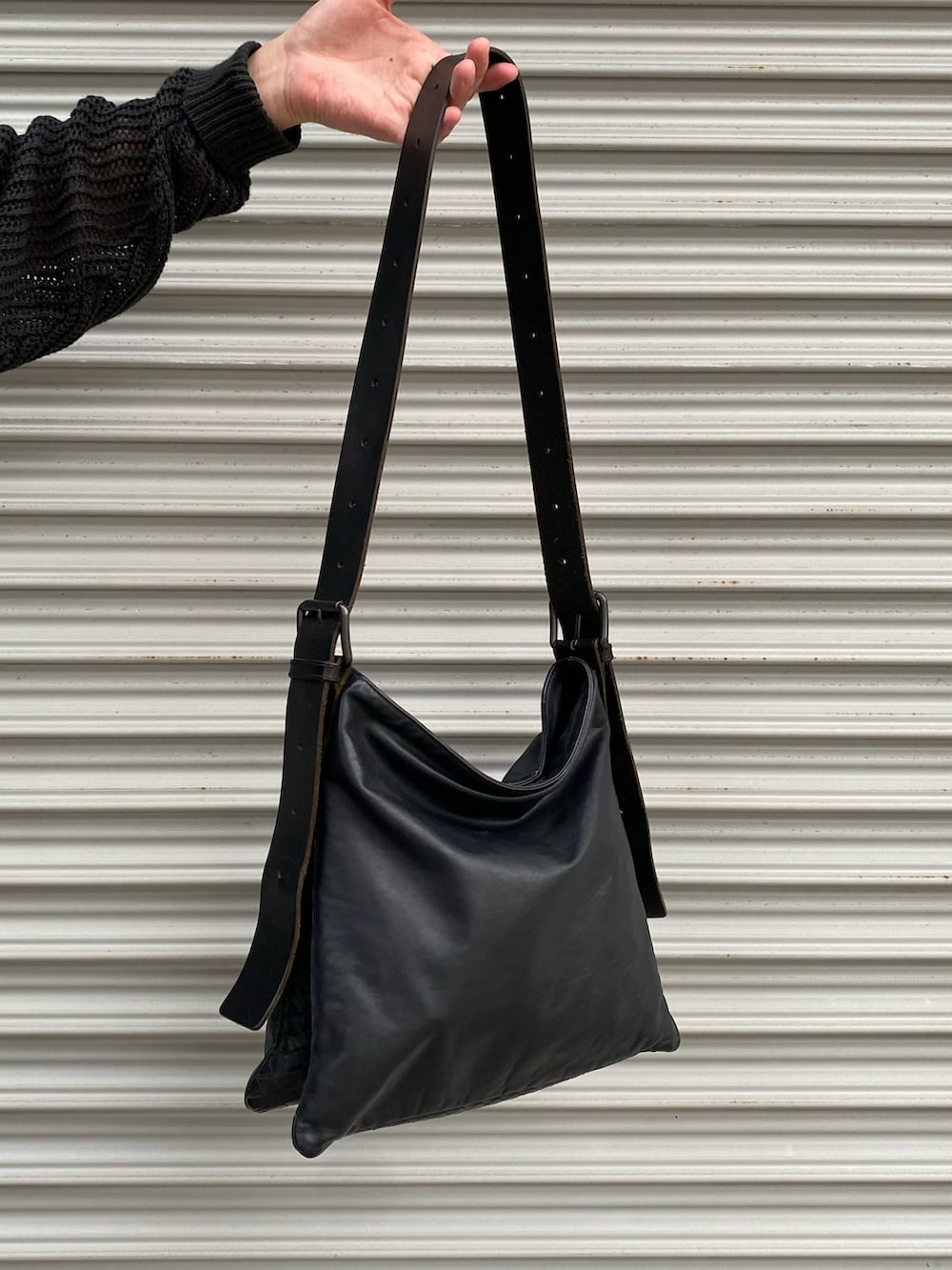 ブラック系のニット/セーター、ブラック系のショルダーバッグ、ブルー系のカーゴパンツを着用したメンズの秋コーディネートの3枚目の写真