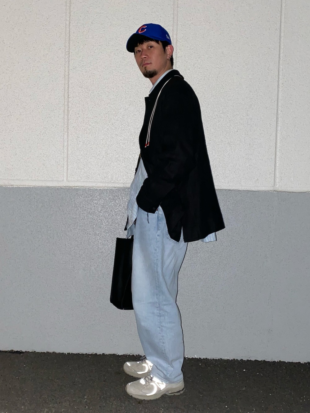 ブラック系のジャケット/アウター、ブルー系のシャツ/ブラウス、ブラック系のバッグを着用したメンズの冬コーディネートの2枚目の写真