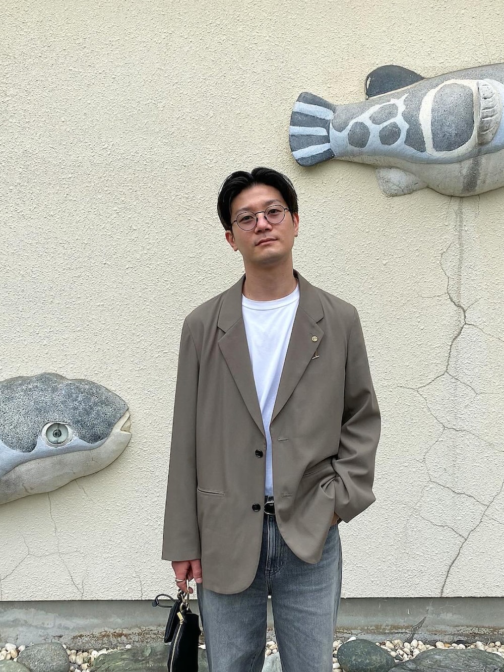 ホワイト系のTシャツ/カットソー、ベージュ系のジャケット/アウター、ブラック系のデニムパンツを着用したメンズの春コーディネートの2枚目の写真