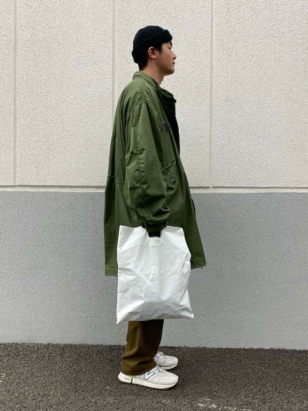 ホワイト系のシャツ/ブラウス、グリーン系のモッズコート、ホワイト系のスニーカーを着用したメンズの春コーディネートの2枚目の写真