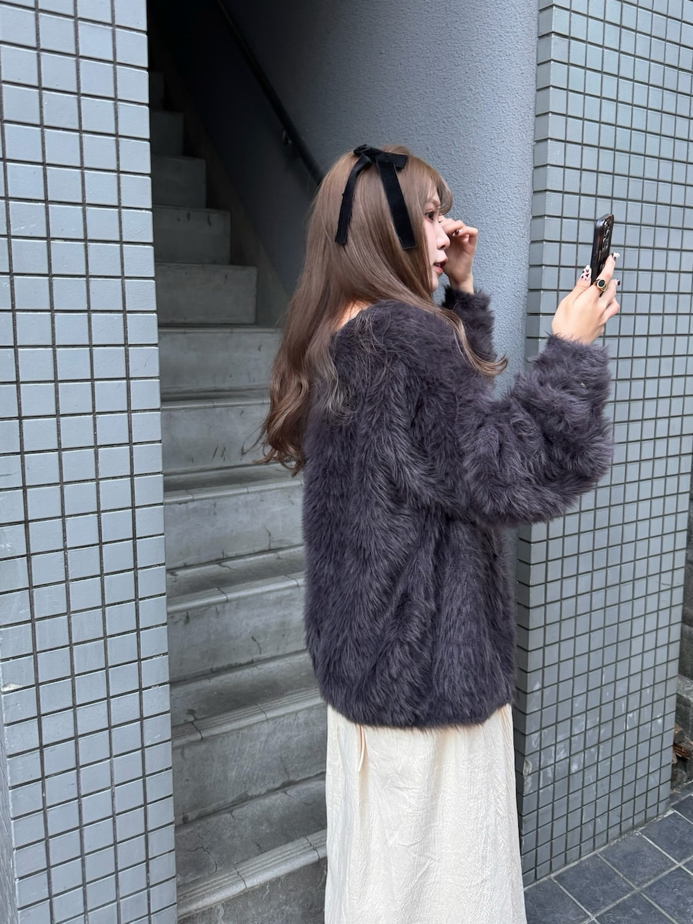 ホワイト系のワンピース、ブラック系のニット/セーター、ブラウン系のハンドバッグを着用したレディースの秋コーディネートの4枚目の写真