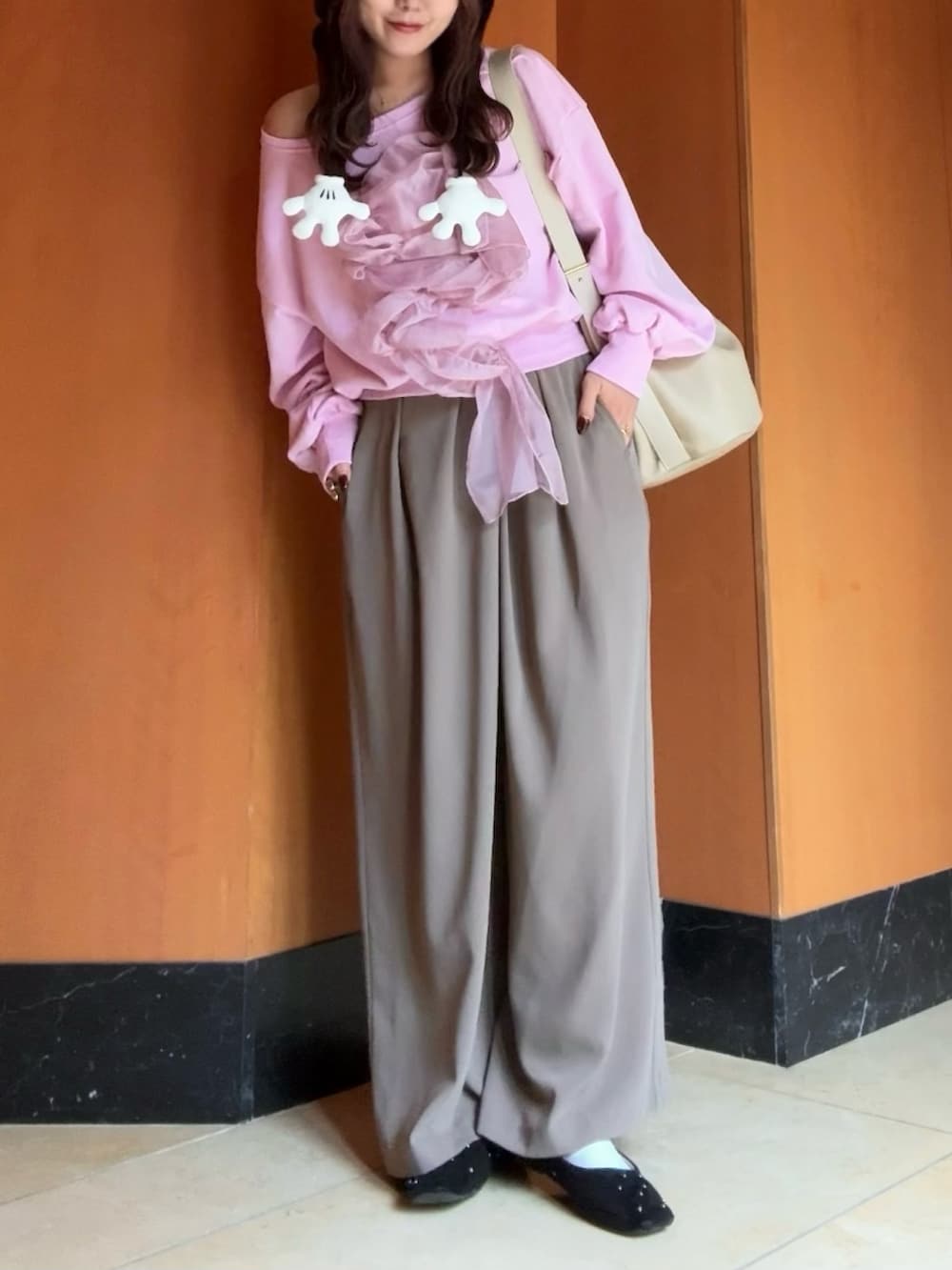 ブラック系のパンプス、ベージュ系のショルダーバッグ、ブラウン系のパンツを着用したレディースの秋コーディネートの3枚目の写真