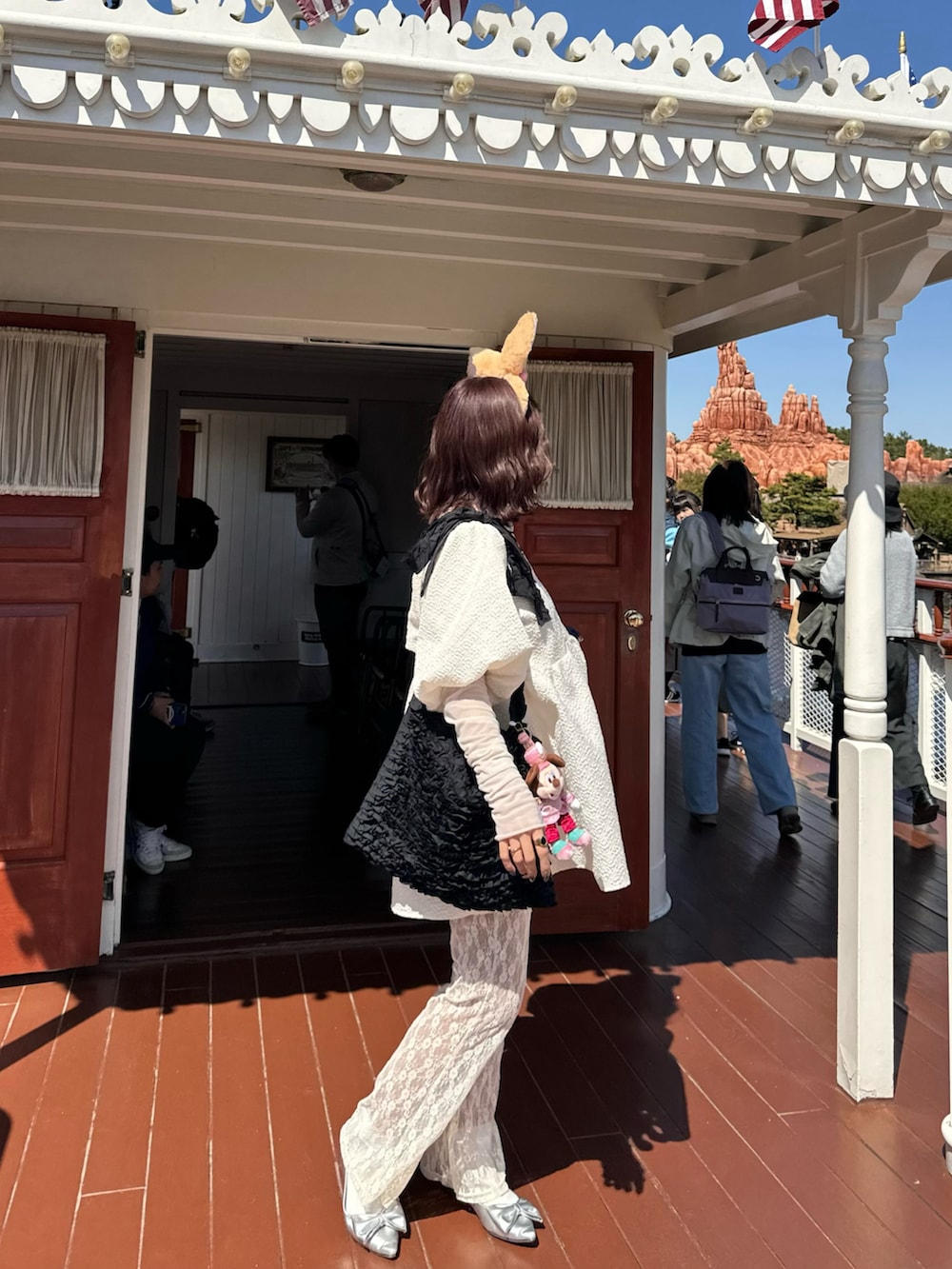 ブルー系のデニムジャケット、ホワイト系のパンツ、シルバー系のパンプスを着用したレディースの夏コーディネートの3枚目の写真