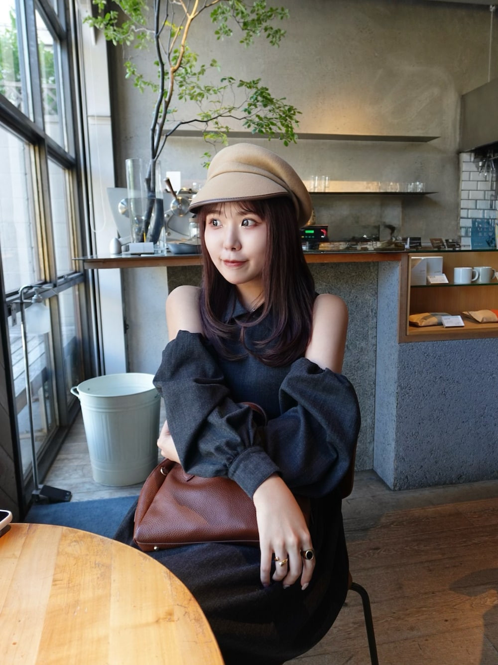 ブラウン系のボストンバッグ、ブラック系のローファー、ブラック系のワンピース/ドレスを着用したレディースの秋コーディネートの4枚目の写真