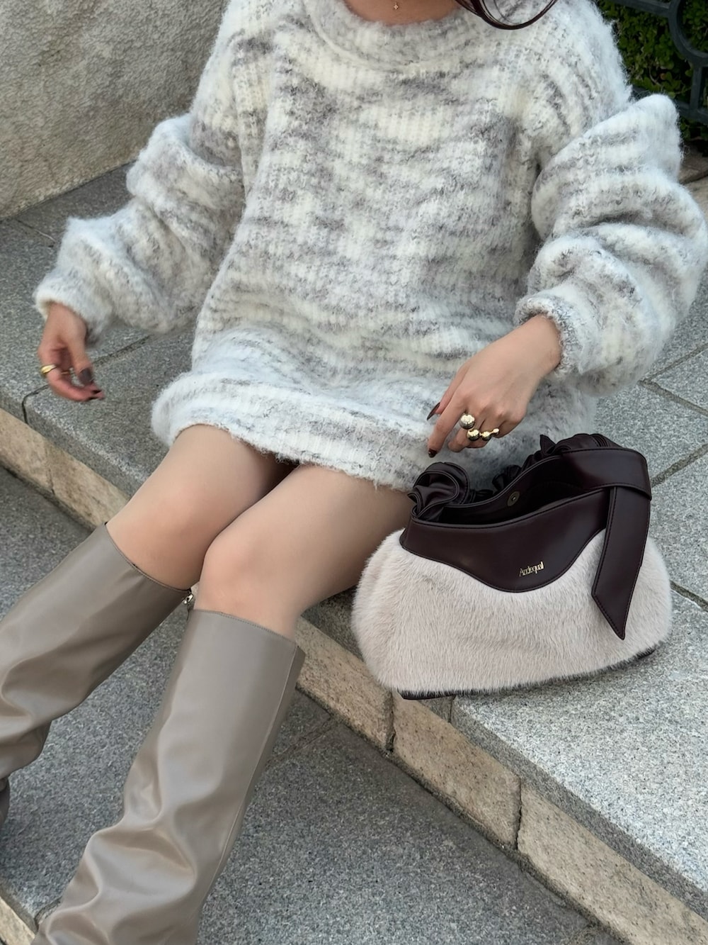 グレー系のニット/セーター、ベージュ系のブーツを着用したレディースの秋コーディネートの2枚目の写真