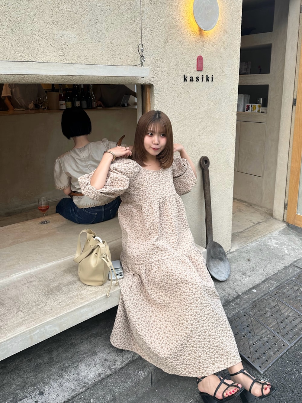 ホワイト系のワンピース、ベージュ系のショルダーバッグ、ブラック系のサンダルを着用したレディースの夏コーディネートの3枚目の写真