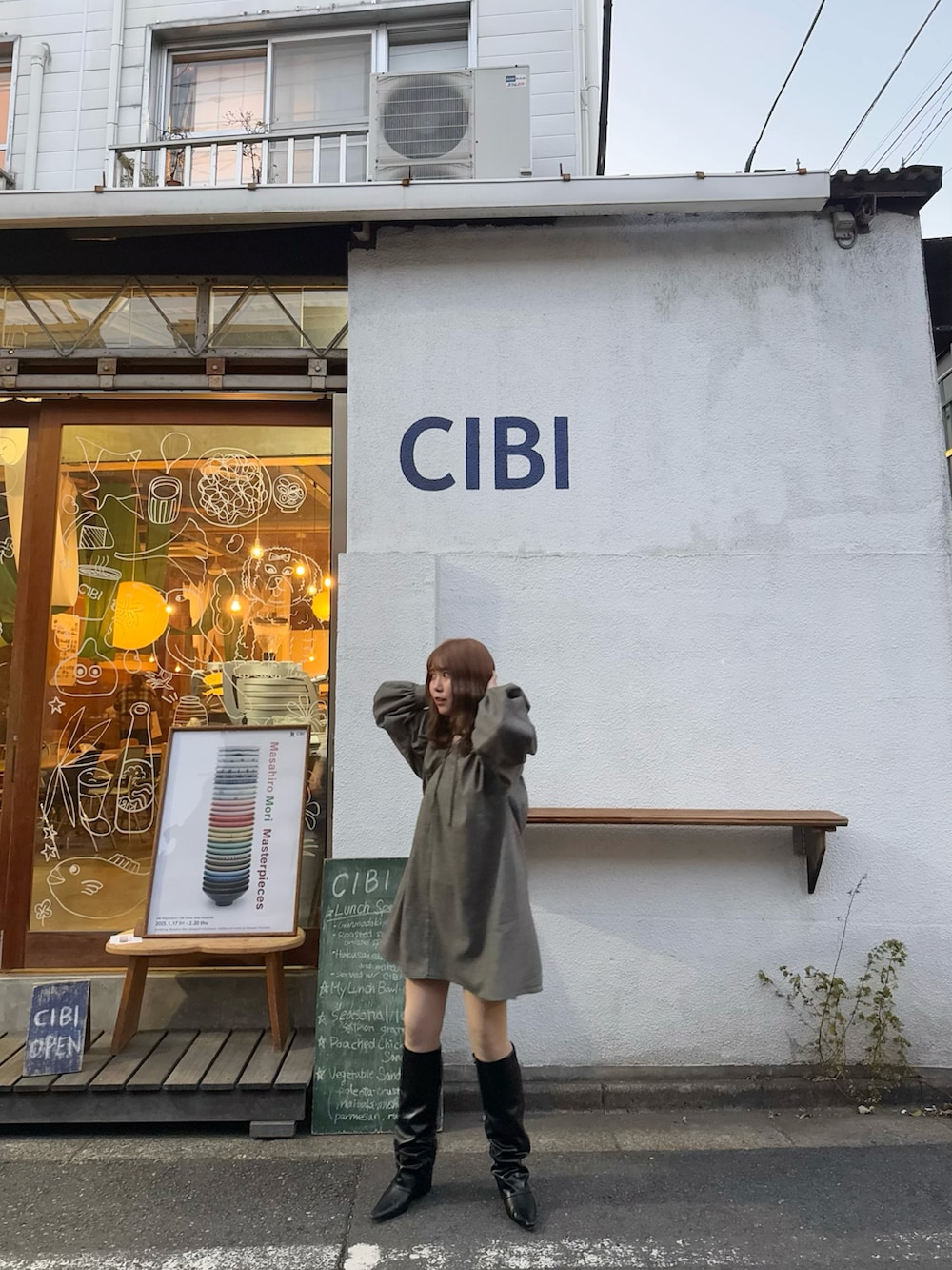 ブラック系のワンピース、ブラック系のブーツを着用したレディースの春コーディネートの2枚目の写真