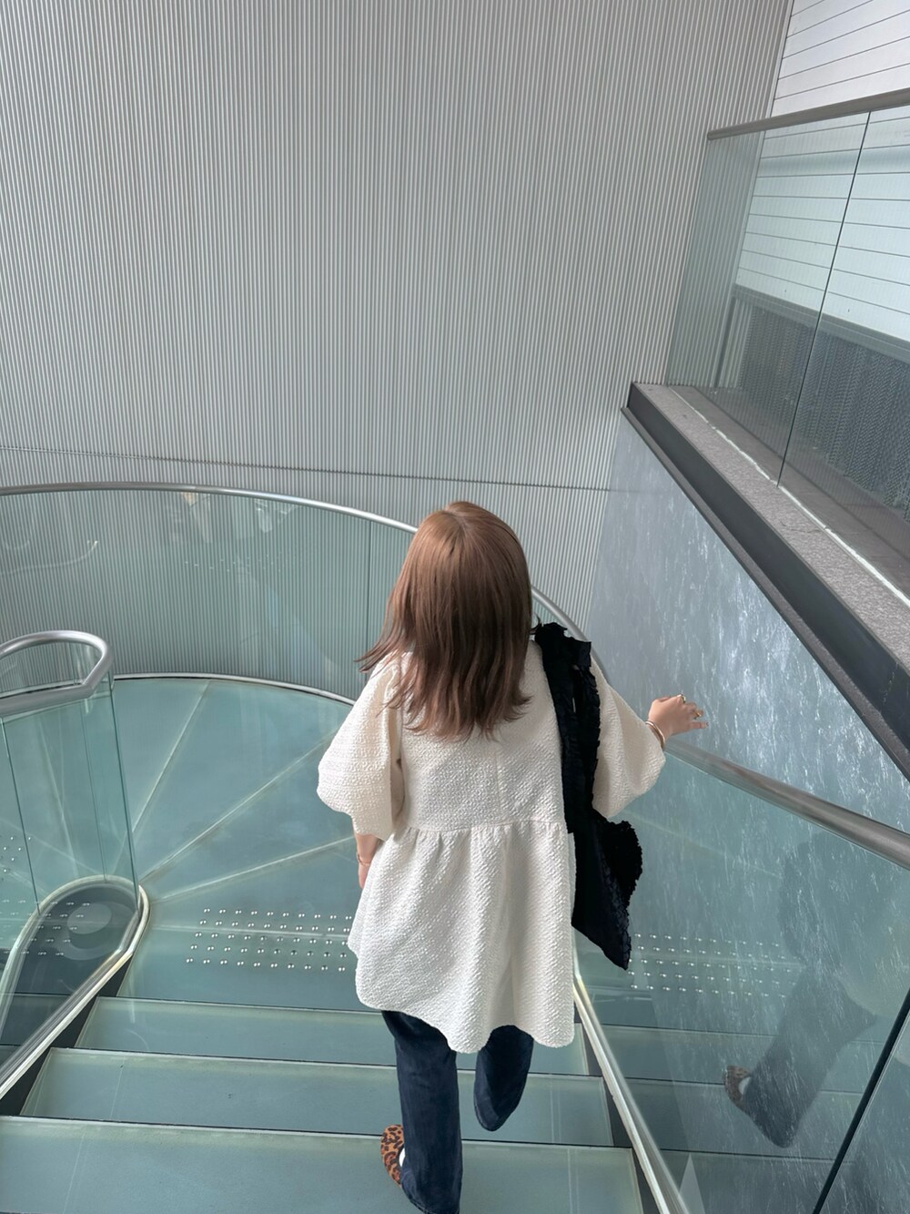 ホワイト系のシャツ/ブラウス、ブルー系のデニムパンツ、ブラウン系のバレエシューズを着用したレディースの夏コーディネートの4枚目の写真