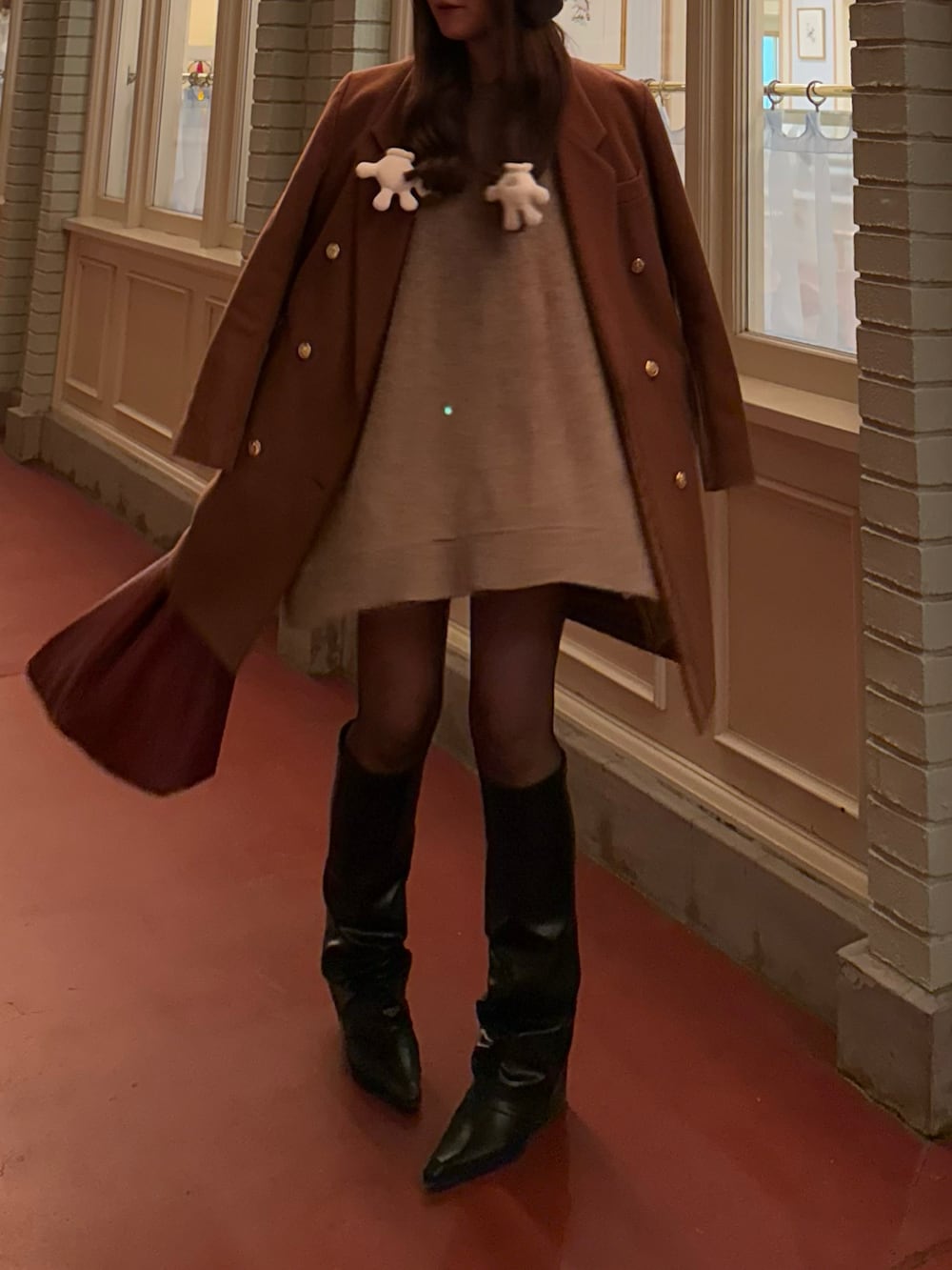 ベージュ系のニット/セーター、レッド系のトートバッグ、ブラック系のブーツを着用したレディースの冬コーディネートの5枚目の写真