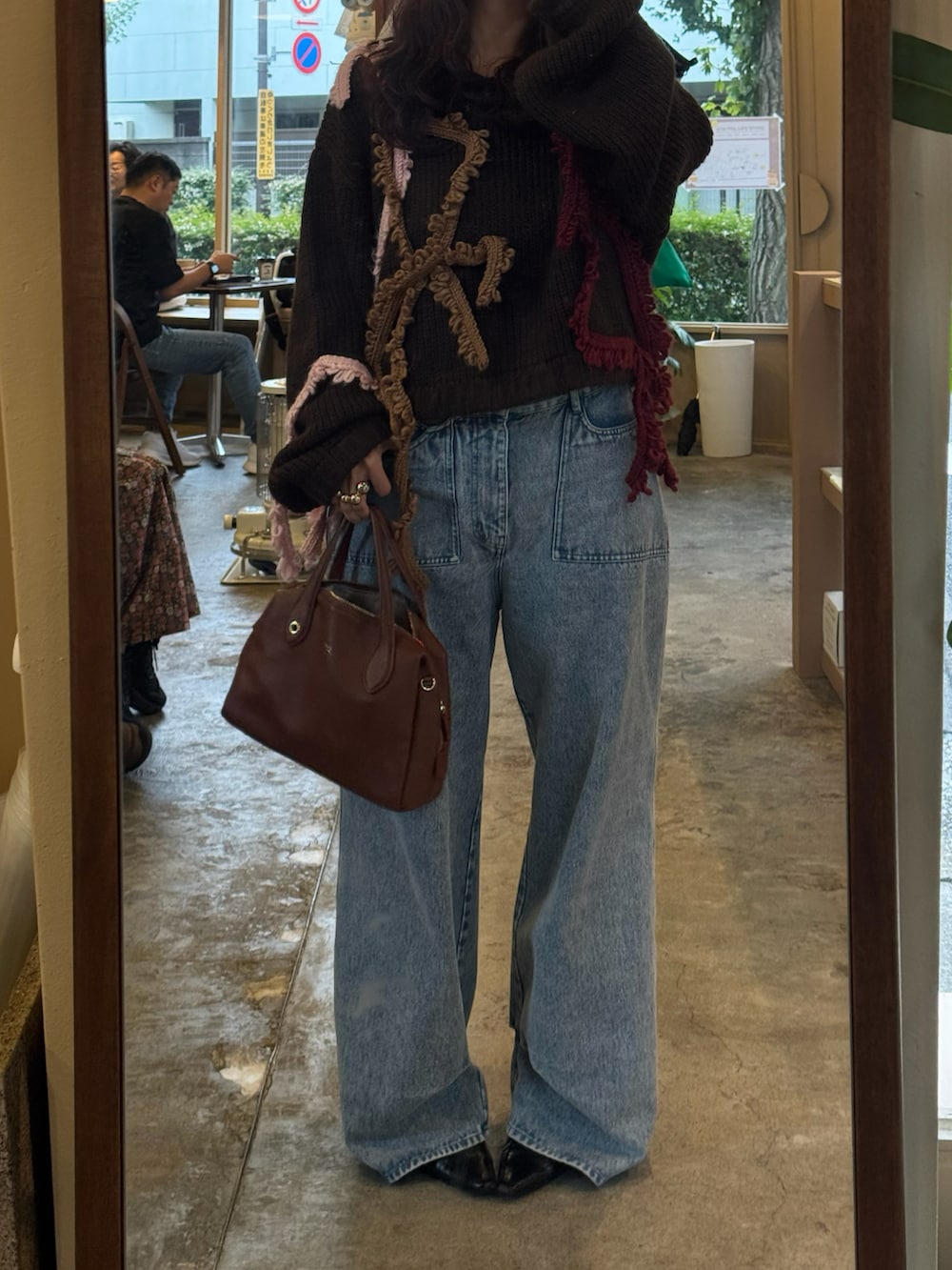 ブラック系のパンプス、ブラウン系のボストンバッグ、ブラウン系のニット/セーターを着用したレディースの秋コーディネートの2枚目の写真