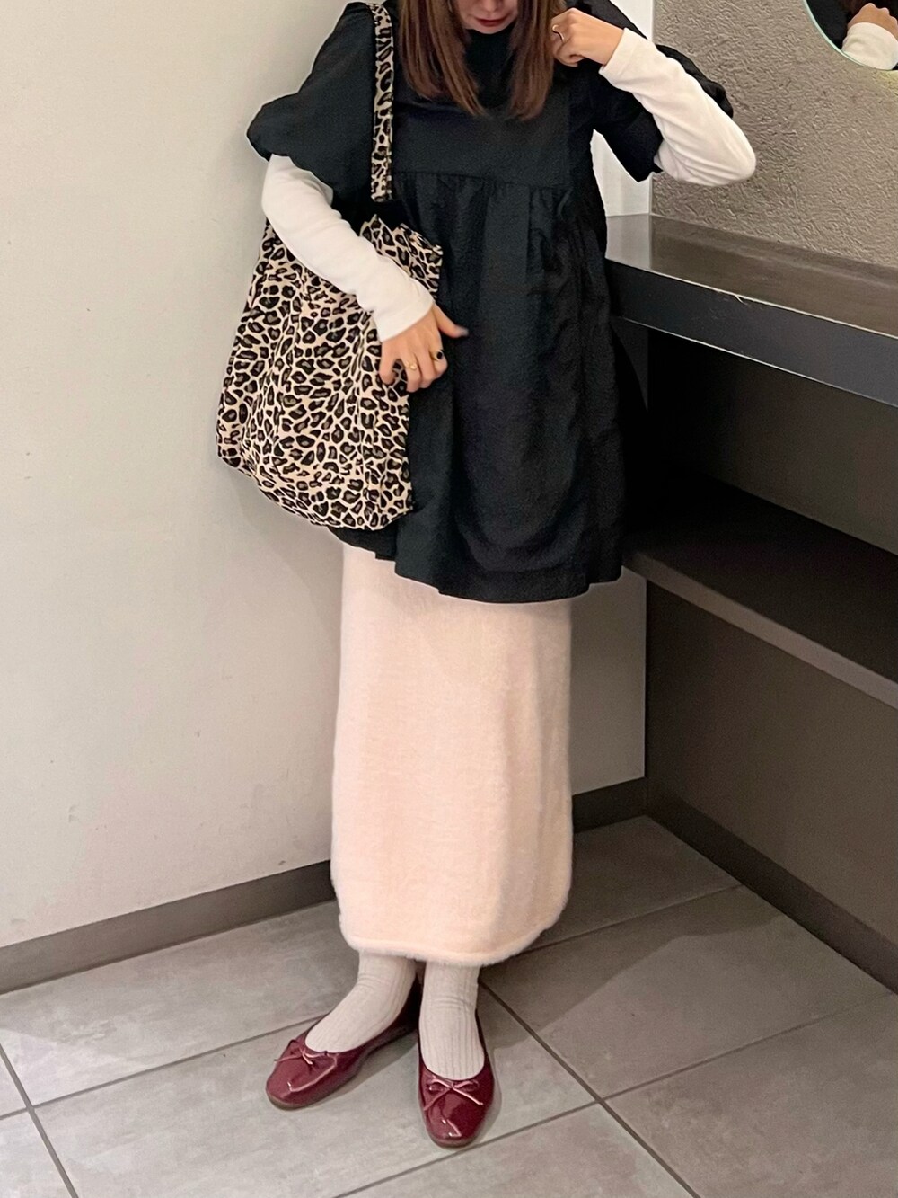 ブラック系のワンピース、ピンク系のスカート、レッド系のバレエシューズを着用したレディースの冬コーディネートの3枚目の写真