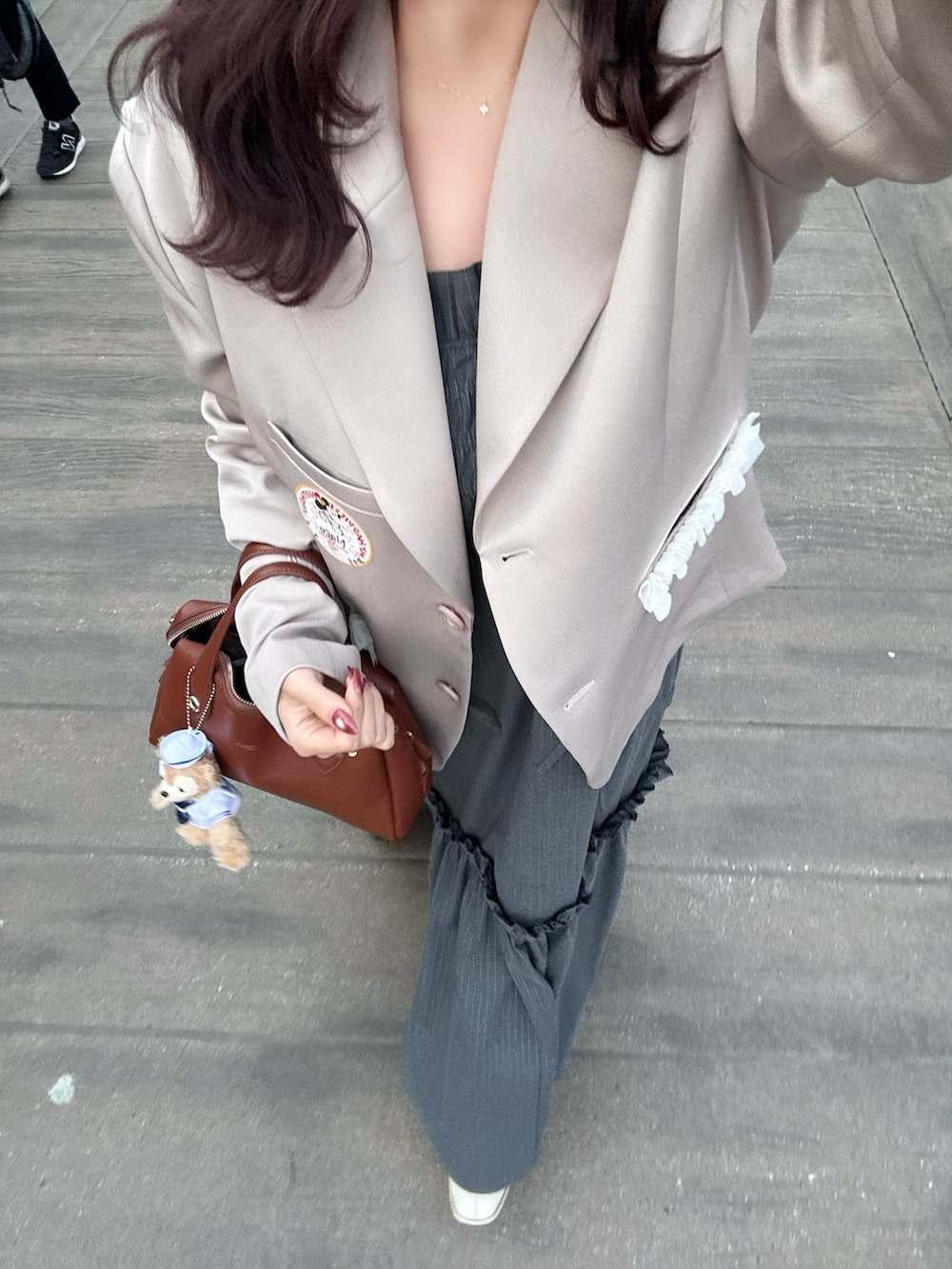 ピンク系のジャケット/アウター、ブラウン系のボストンバッグ、ブラック系のワンピースを着用したレディースの春コーディネートの4枚目の写真