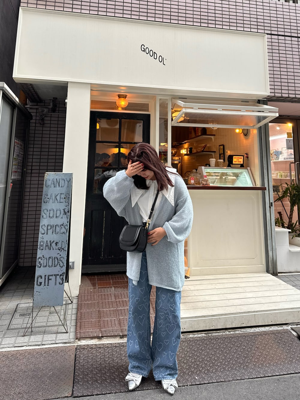 シルバー系のパンプス、ブルー系のカーディガン/ボレロ、ブラック系のショルダーバッグを着用したレディースの春コーディネートの4枚目の写真