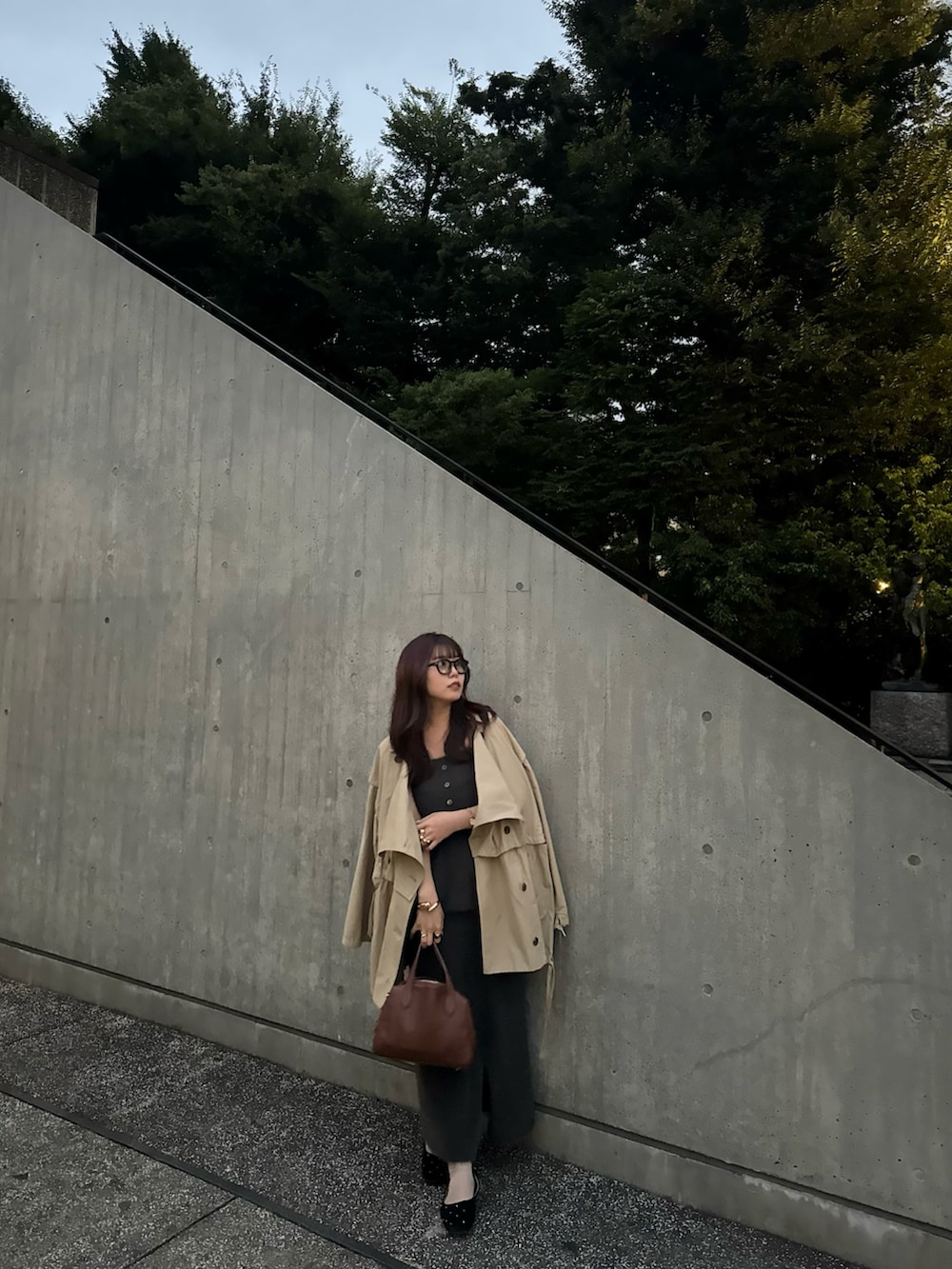 ブラック系のパンプス、グレー系のスカート、ブラウン系のボストンバッグを着用したレディースの秋コーディネートの3枚目の写真